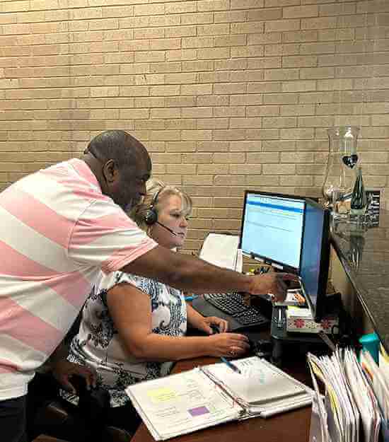 A male and female professional team working diligently on computers in an office