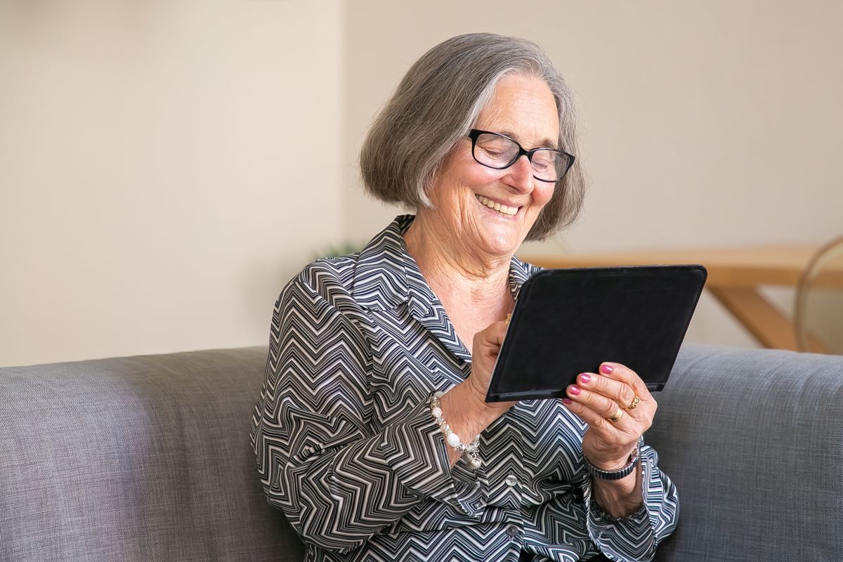 Smiling senior woman exploring a creative app on her tablet